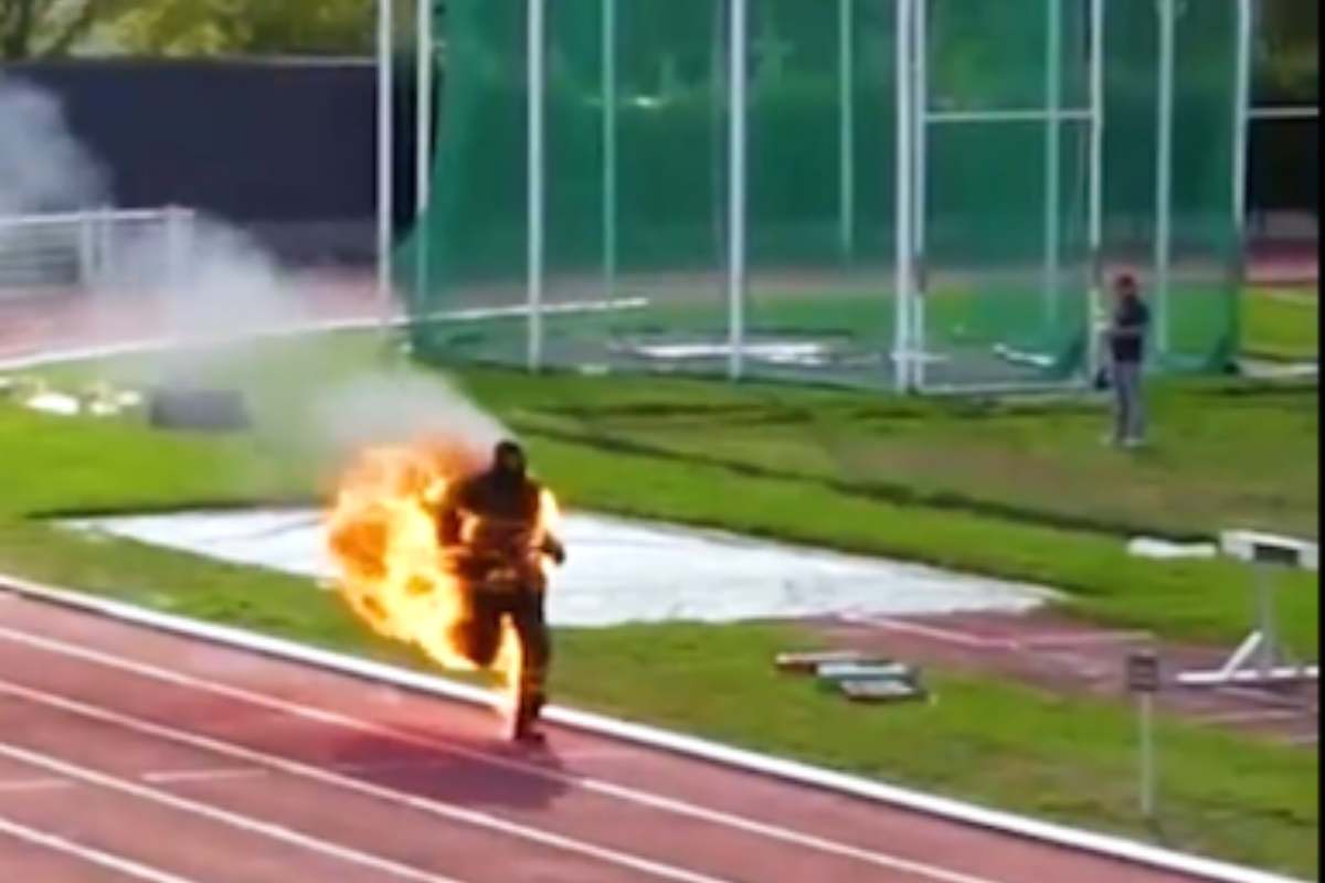 Uomo in fiamme corre su pista atletica