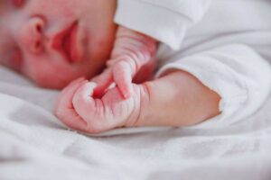 bambino neonato che si tocca le manine