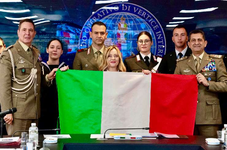 Giorgia Meloni con i militari e la bandiera dell'italia