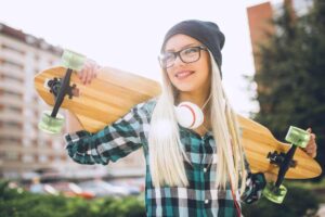 Ragazza con lo skateboard in una giornata di sole