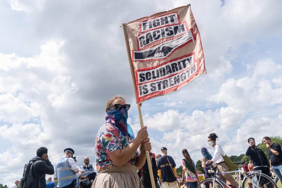 Una donna con uno striscione contro il razzismo in America