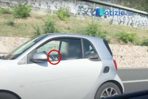 Una persona in autostrada guida utilizzando lo smartphone