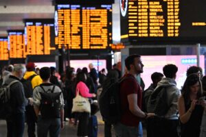 stazione treni e tabelloni con tanta gente