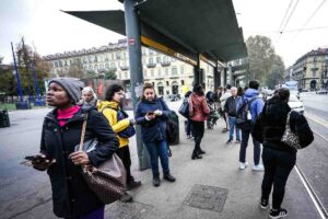 gente ferma a una banchina in attesa del bus