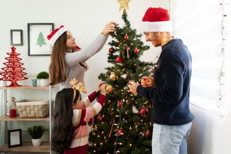 Una coppia di fidanzati addobba l'albero di Natale