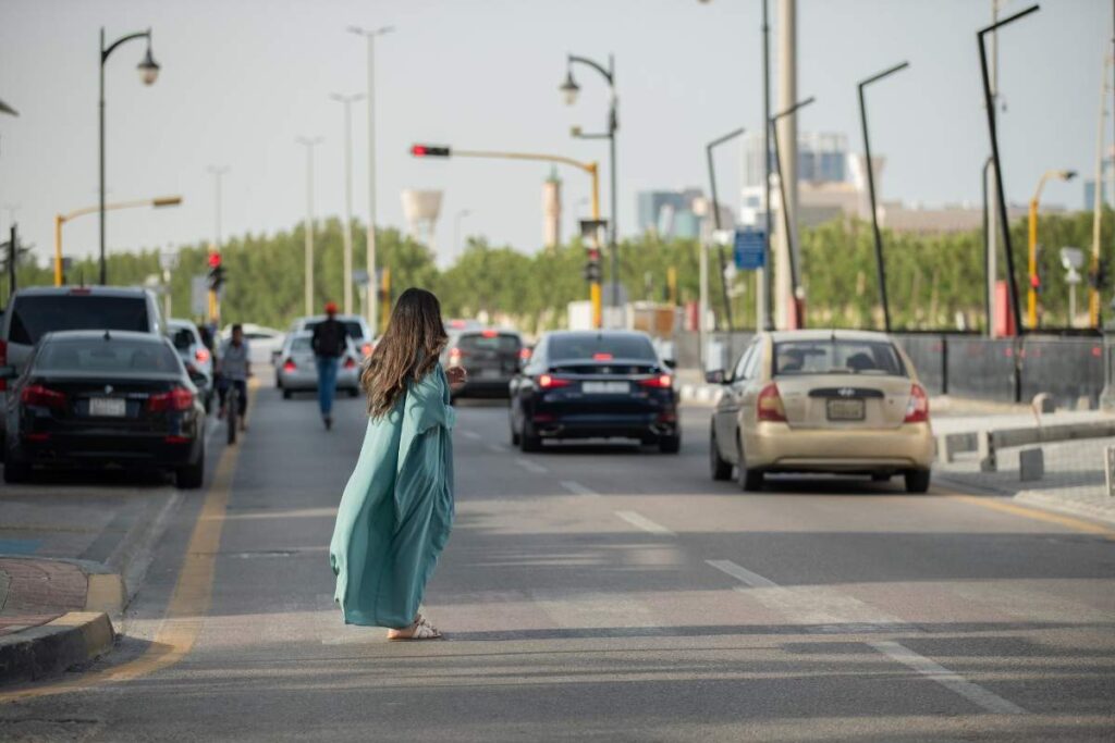 Una donna attraversa sulle strisce pedonali tra le automobili