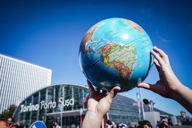 Un mappamondo esposto da un manifestante di Fridays for Future durante una manifestazione a Torino, fuori dalla stazione di Porta Susa