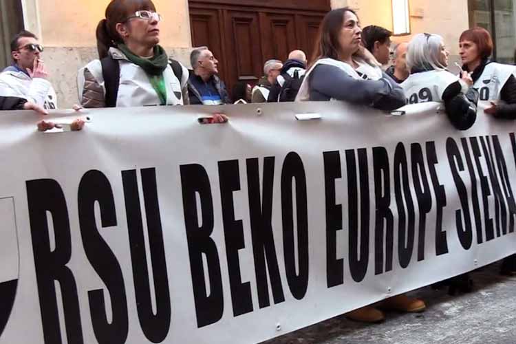 lavoratori in protesta dietro uno striscione