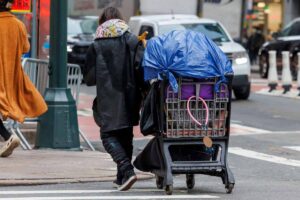 Clochard trascina il suo carrello pieno di effetti personali