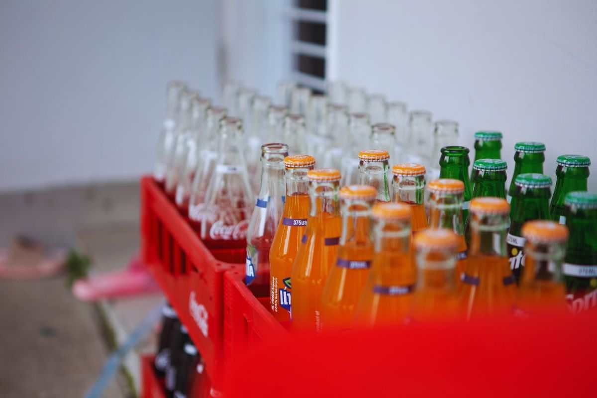 coca fanta e sprite in bottiglie di vetro dentro una cassetta