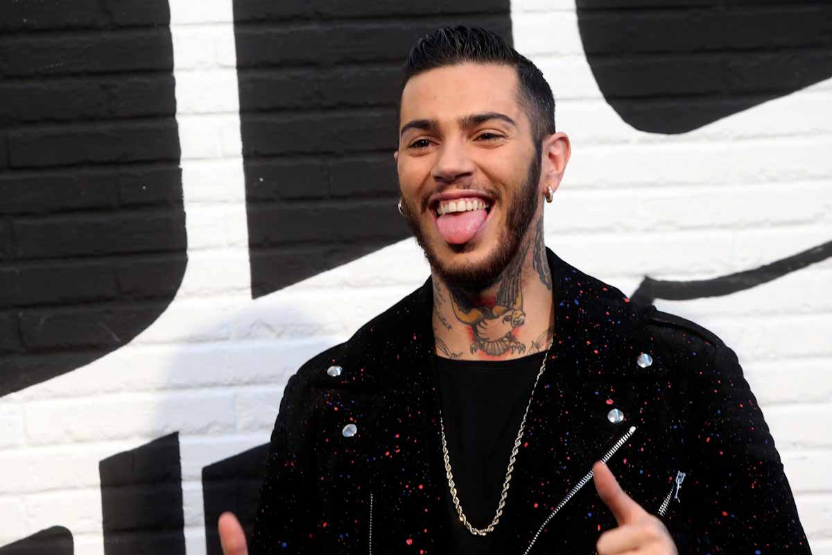 il rapper Emis Killa ripreso in primo piano mentre fa una smorfia