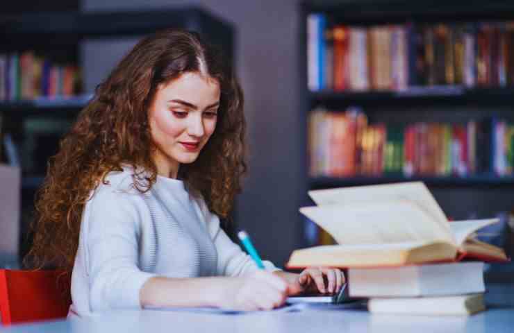 ragazza fa esame con un vocabolario a fianco