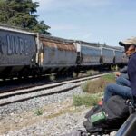 un uomo seduto sui binari del treno