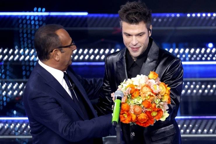 Carlo Conti dà i fiori a Fedez dopo l'esibizione a Sanremo con Marco Masini