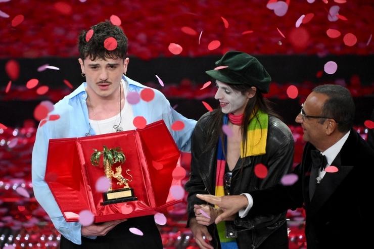 Olly riceve il premio del vincitore del Festival di Sanremo. Con lui sul palco il secondo classificato Lucio Corsi e il conduttore Carlo Conti