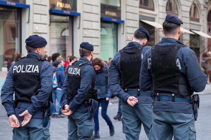 Agenti di polizia durante un controllo per strada, ripresi di spalle