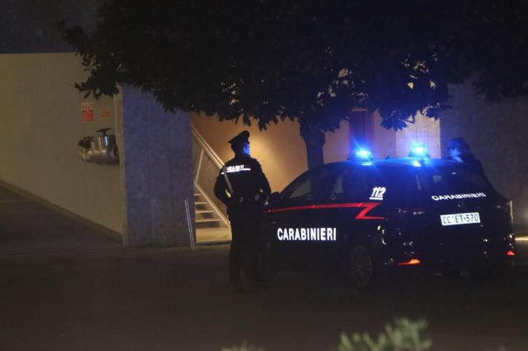 carabinieri sotto un appartamento di notte con le sirene accese