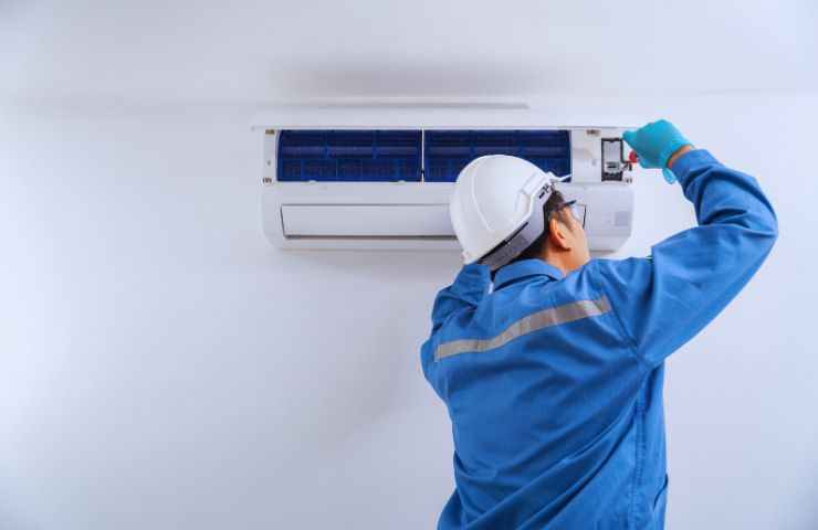 un tecnico lavora sulla pompa di calore all'interno di casa