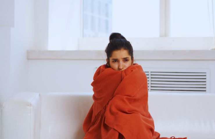 ragazza influenzata in una coperta