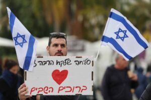 uomo con bandiere di israele e un cartellone