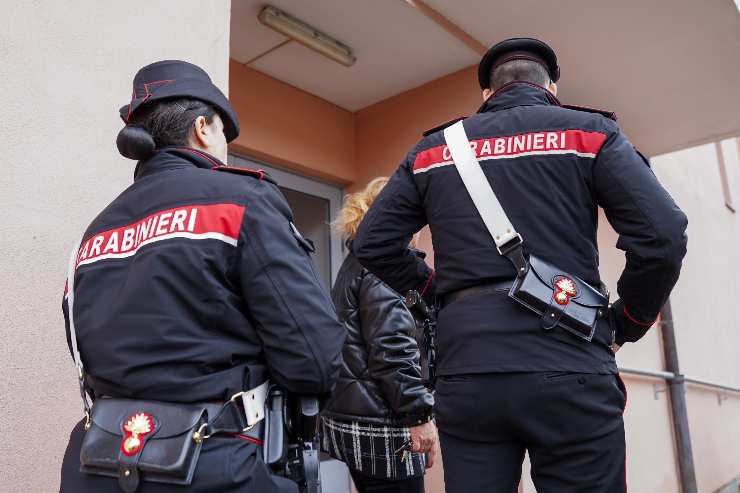 carabinieri entrano in un palazzo, una donna e un uomo