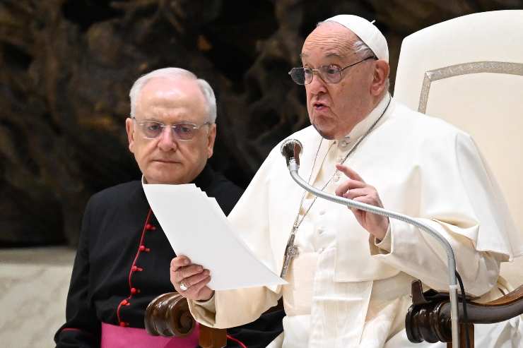 papa francesco parla al microfono con un foglio in mano