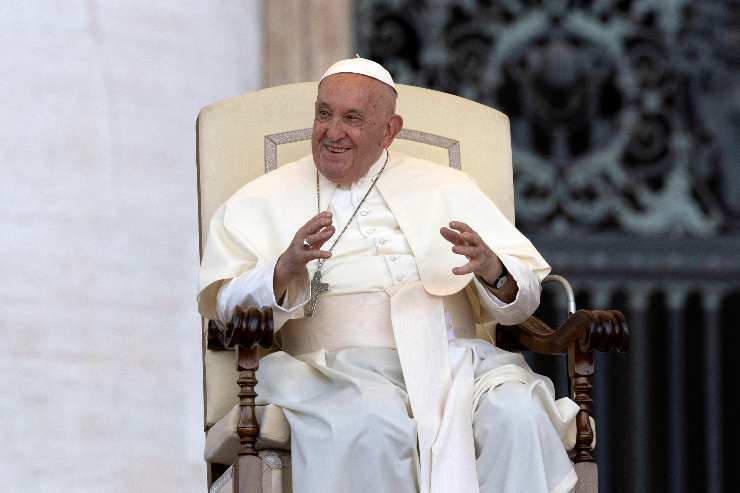 papa francesco seduto gesticola e sorride