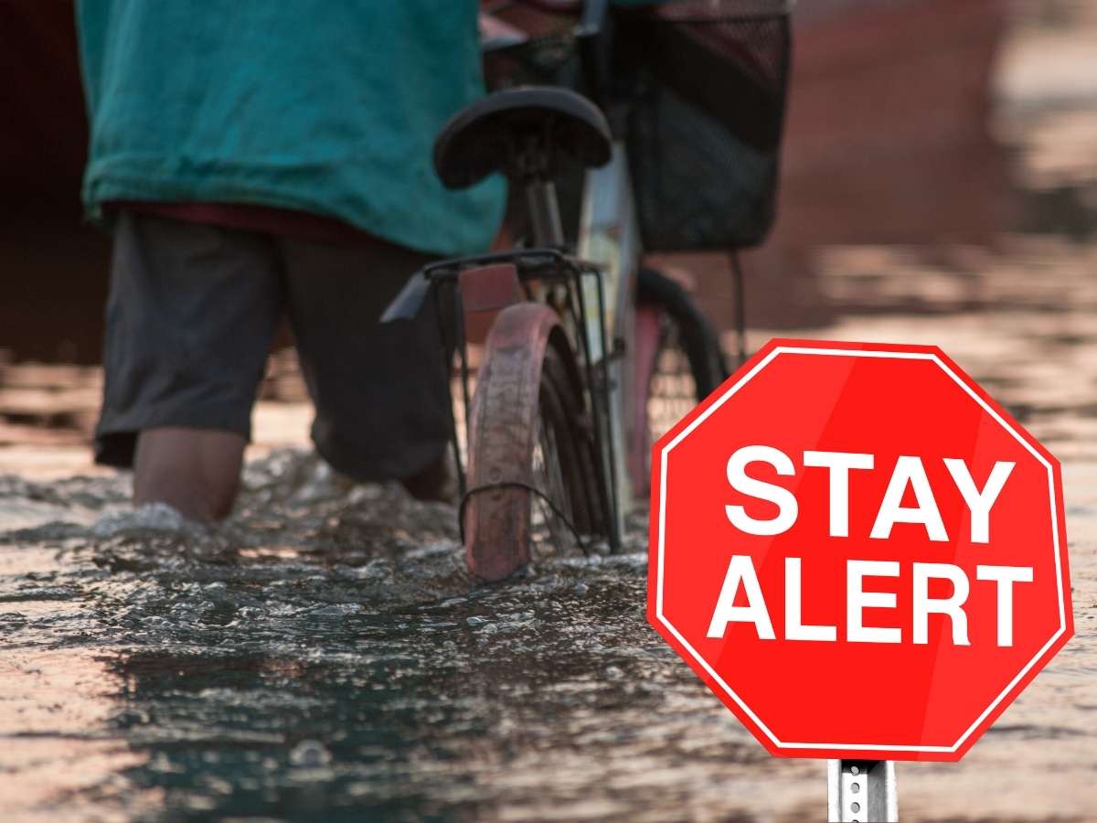 Un ragazzo in bici sotto la pioggia