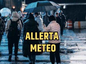 Persone in strada sotto la pioggia durante l'allerta meteo