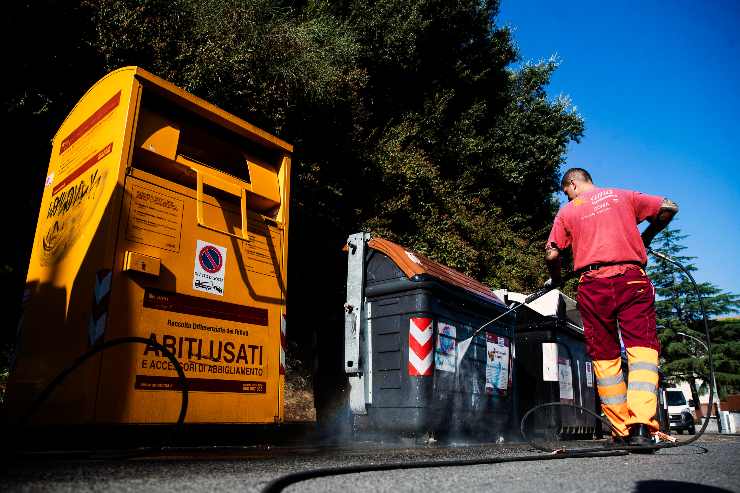 secchioni della spazzatura e un operatore che pulisce