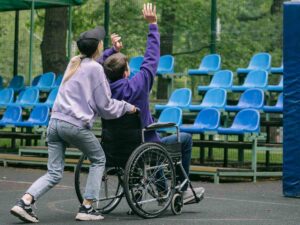 Disabile che gioca in un parco insieme a un cargiver