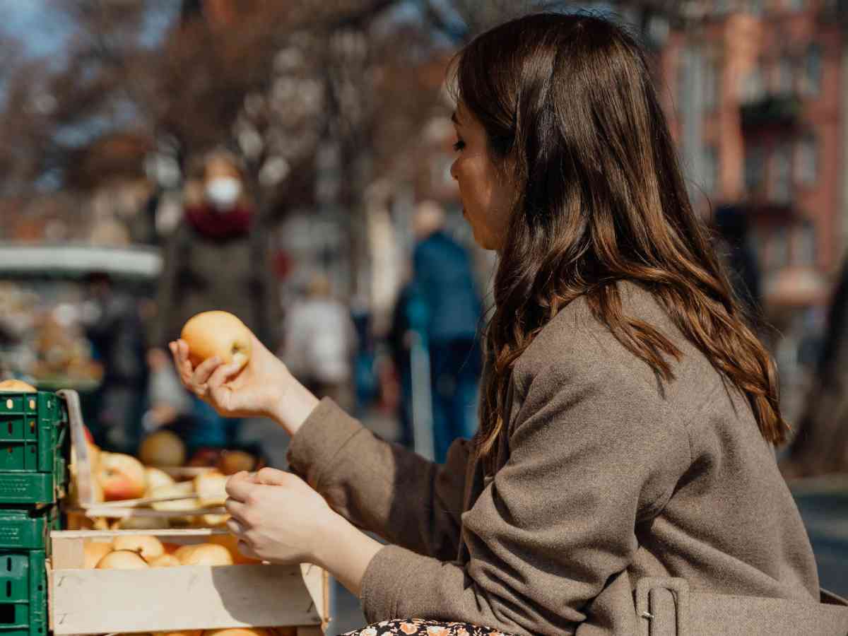 Donna che acquista delle mele al mercato