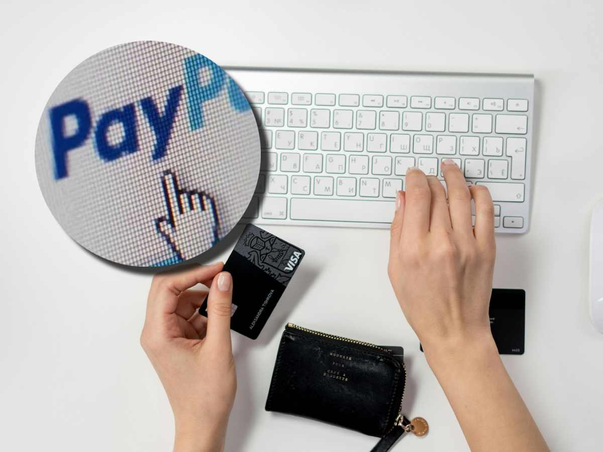 Donna che usa la carta di debito sul computer, con in evidenza il logo di PayPal