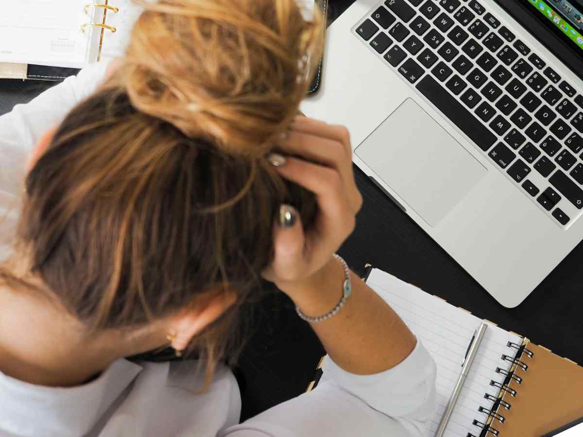 Ragazza al computer con le mani fra i capelli