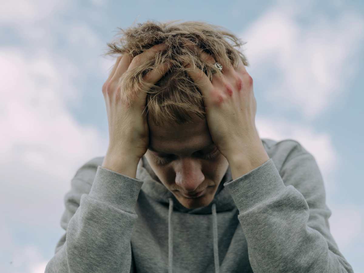 Un giovane disperato con le mani fra i capelli