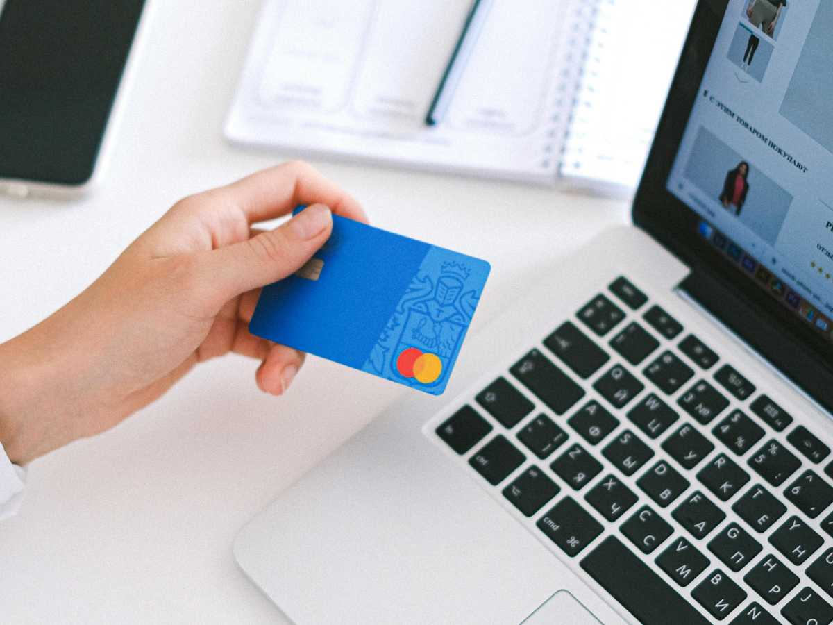 Una mano regge una carta di credito per un pagamento online